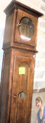 une femme debout à côté d'une horloge de parquet dans une pièce