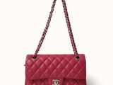 a red chanel bag with a chain hanging from it