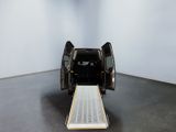 an image of a black van with its door open in a white room