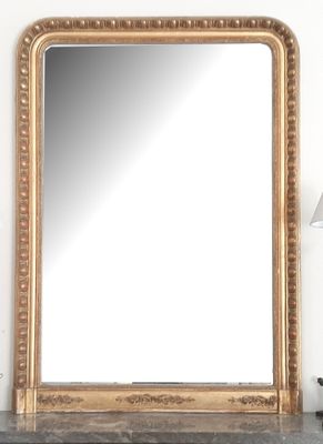 un miroir posé sur une table, à côté d'une lampe