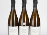 trois bouteilles de vin posées les unes à côté des autres sur une surface blanche