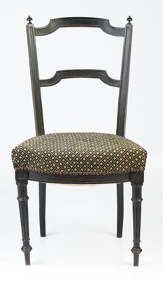 une chaise noire dont l'assise et le dossier sont à motifs