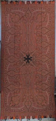 a brown rug hanging on a wall next to a chair