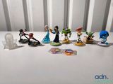 Des figurines Disney sont alignées sur une table blanche