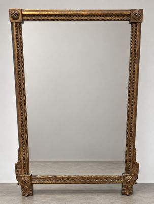 a large gold framed mirror with ornate carvings on the sides