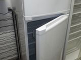 un réfrigérateur blanc dont la porte est ouverte, dans une cuisine