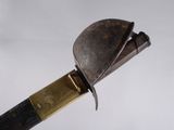 un couteau avec un manche en métal posé sur une surface blanche