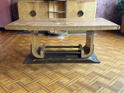 une table en bois avec un piètement en métal posée sur un parquet en bois dur