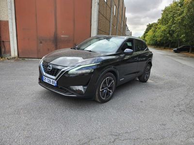 une Nissan QX noire garée devant un immeuble