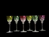 six verres à vin sont alignés sur fond noir