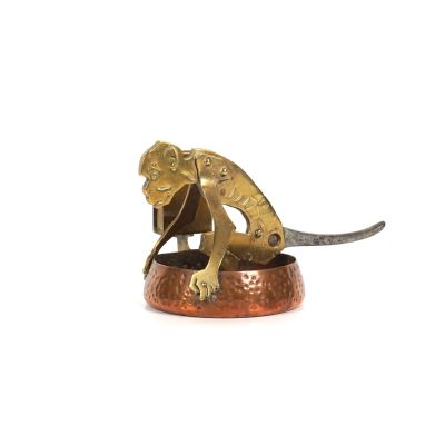 une figurine en bronze représentant un singe tenant un couteau
