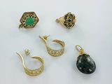 three pairs of gold earrings and a ring with a green stone
