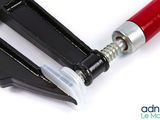 a pair of pliers with a red handle on a white surface