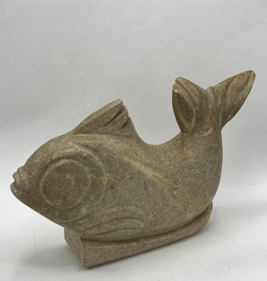 statue of a fish made of stone on a white background