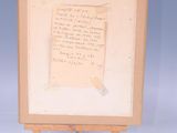 an old piece of paper on an easel with a piece of writing on it