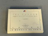 une image représentant une boîte blanche sur laquelle figure une étiquette rouge, blanche et bleue