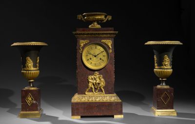 trois vases et une horloge posés sur une table