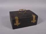 a black suitcase with gold handles on a white surface