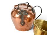 a copper pot and a brass cup on a white surface