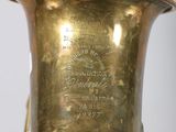 a gold vase that has a label on it
