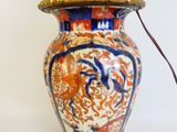 a large vase with a handle on a white surface