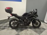 a black motorcycle parked in a room with a checkered floor
