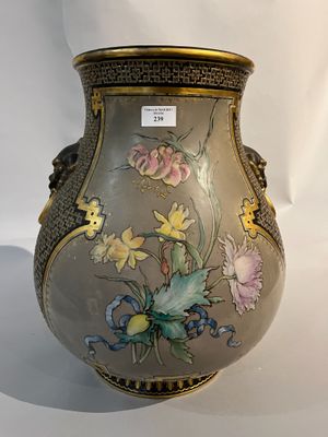un vase orné de fleurs peintes, posé sur une surface blanche