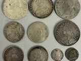 a group of silver coins sitting on top of a white surface
