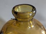 a yellow glass vase sitting on a white table