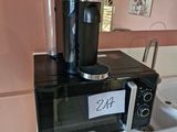 une cafetière posée sur un micro-ondes, sur un plan de travail
