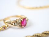 a gold ring with a pink stone and a gold chain