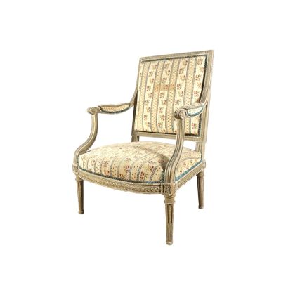 La chaise est en bois et son assise est rembourrée et ornée d'un motif.