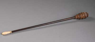 an old wooden stick with a wooden handle on a gray surface