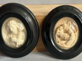 pair of carved ivory and black oval picture frames of the virgin and child