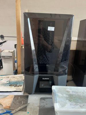 un homme qui se tient devant une imprimante 3D