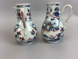 pair of blue and white vases with flowers on them sitting on a table