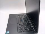 a black laptop with a blue button on the keyboard