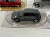 three toy cars on display in plastic cases on a table