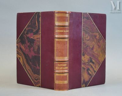 an old book with a red cover sitting on top of a white table