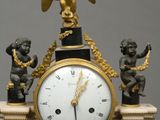 a clock that has statues on top of it