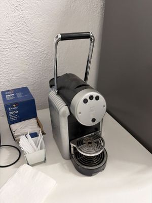 une cafetière posée sur une table à côté d'une boîte de mouchoirs