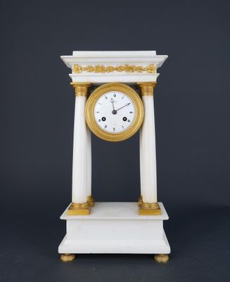 une image représentant une horloge blanche et dorée posée sur une table