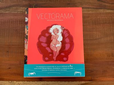 le livre est posé sur une table en bois, avec une couverture rouge