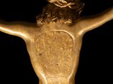 a gold statue of a man with a cross on his back