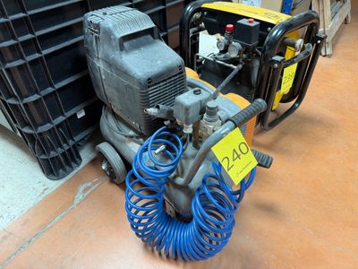 a blue hose on the floor next to a small air compressor
