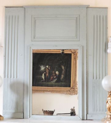 un tableau accroché au mur au-dessus de la cheminée dans un salon