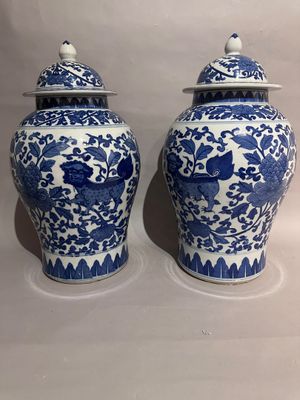 two blue and white vases with lids on a white surface