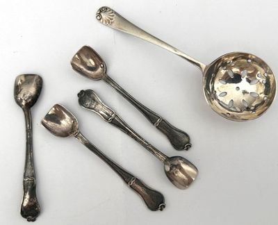 five spoons and a ladle on a white surface