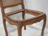 a wooden chair that has a wicker seat on it