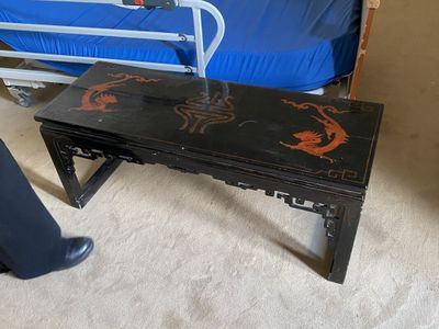 un lit et une table dans une chambre avec un lit bleu